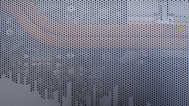 金属格栅纹理的笔记本电脑的情况。带圆孔的金属格栅盖在电脑外壳上图片下载