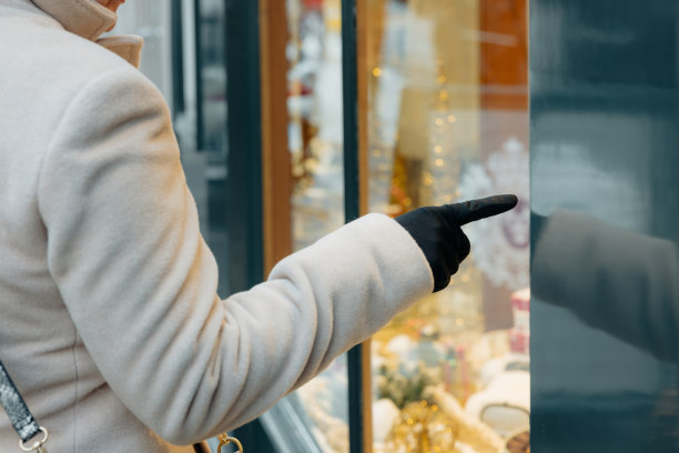 成年妇女的手臂，她的手指着巴黎一家商店的橱窗图片下载