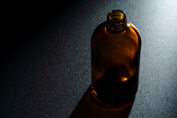 棕色药瓶在黑暗的背景图片下载