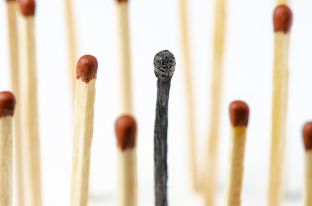 在白色背景上燃烧的火柴。工作中倦怠综合症的概念。放大照相图片下载