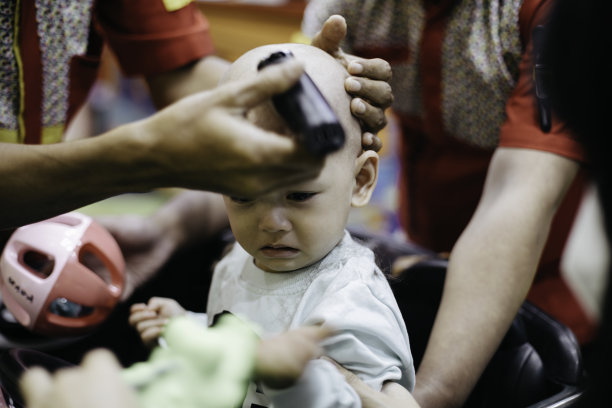 哭闹的亚洲婴儿剪头发图片下载