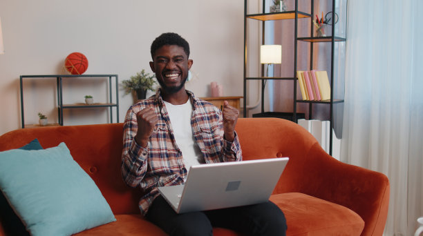 非洲裔美国年轻人坐在沙发上关闭笔记本电脑下班后在线在客厅图片下载