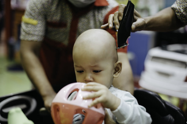 哭闹的亚洲婴儿剪头发图片下载