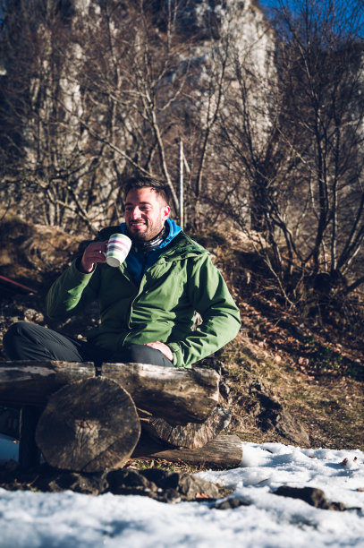 冬天阳光明媚的早晨，一个人在大山下露营图片下载