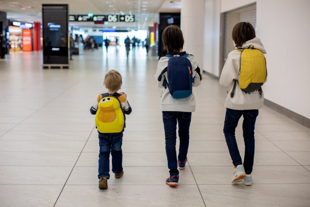 可爱的小男孩在机场登机口附近的中转大厅等待登机。积极的家庭生活方式与孩子乘飞机旅行图片下载