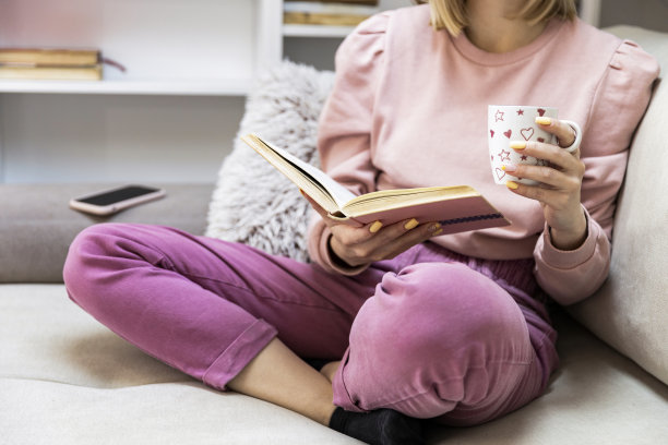 一张年轻女子躺在客厅看书的照片图片下载