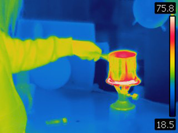 女性在燃烧野营用的天然气炉子上煮茶的热图像图片下载