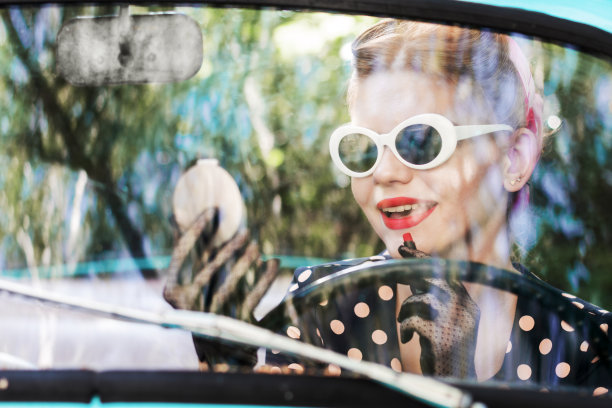 海报女郎在旧车里化妆。图片下载