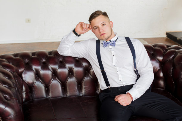 有魅力的年轻人，未来的一代，坐在沙发上思考工作的商人。图片下载