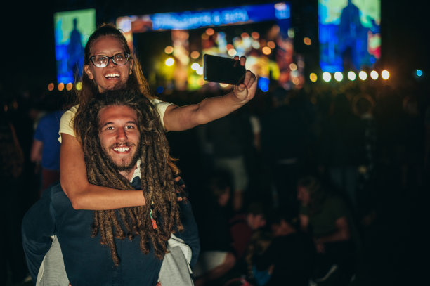 一对情侣在音乐节上用智能手机自拍图片下载