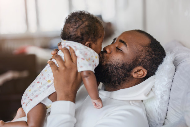 父亲在家里亲吻他刚出生的婴儿图片下载