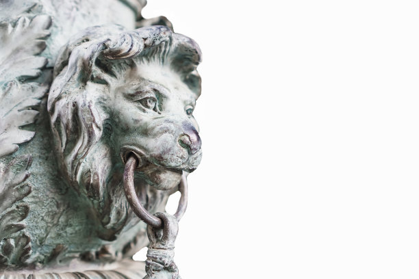 白色背景的金属狮子头部侧面雕塑。图片下载