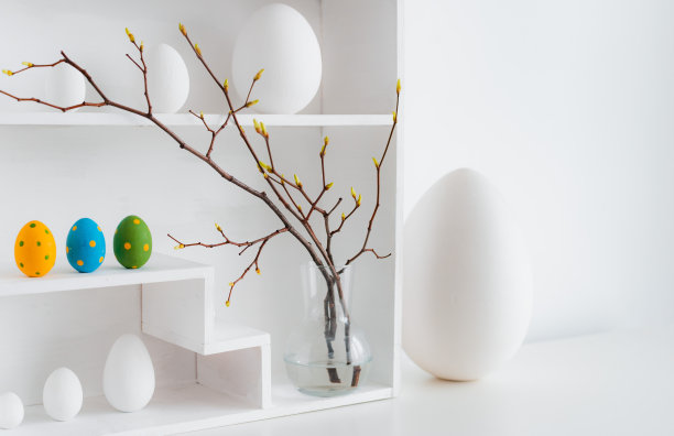 复活节装饰的家庭简约内饰。枝条插在玻璃花瓶里，摆成房子的形状，图片下载
