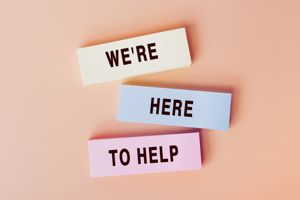 我们是来帮忙的。色卡上文字的概念。顶部视图图像的卡片和在柔和的米色背景。平把设计图片下载