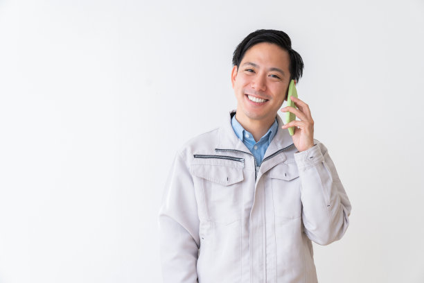 亚洲年轻建筑工人，在电话里说话图片下载