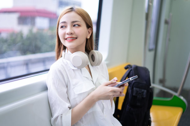 年轻的亚洲女性在地铁上使用智能手机的图片图片下载