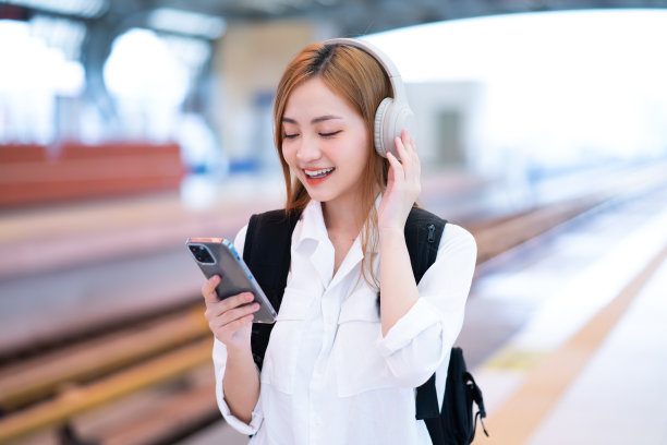 年轻的亚洲女孩在车站等火车图片下载