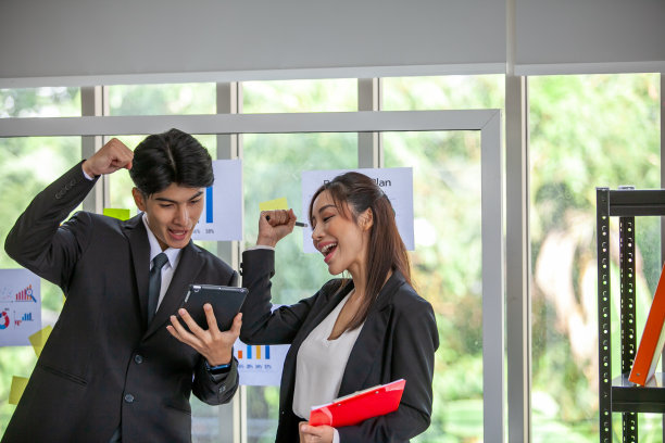 年轻快乐的多种族同事在玻璃板上一起工作。图片下载