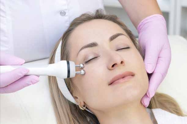 硬件美容。近距离图片可爱的年轻女子与闭着眼睛接受射频提升程序在美容院。图片下载