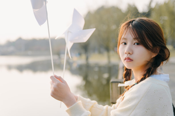 一个美丽的亚洲女孩在黄昏湖边图片下载