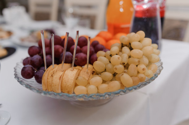 不同的新鲜水果在婚礼自助餐桌上。婚宴餐饮桌上摆放着不同的水果。配餐桌上有不同种类的水果图片下载
