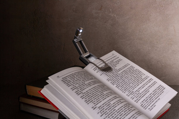 便携式手电筒，在黑暗中阅读，附在一本书，选择性聚焦图片下载