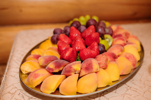 不同的新鲜水果在婚礼自助餐桌上。婚宴餐饮桌上摆放着不同的水果。配餐桌上有不同种类的水果图片下载