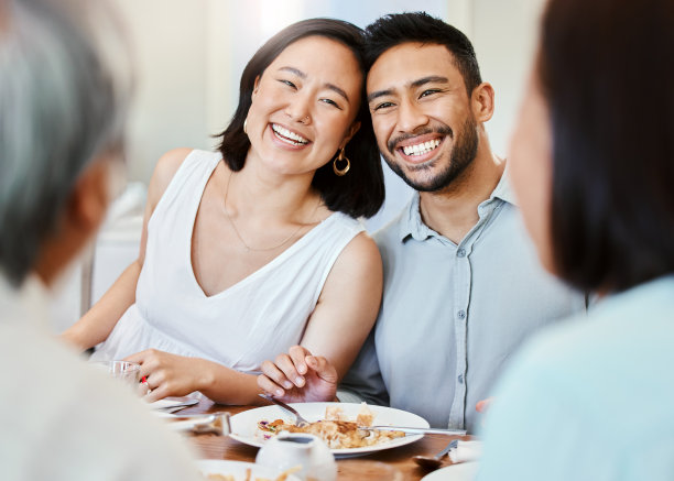 这张照片拍摄的是一对年轻夫妇和家人在家里吃午饭图片下载