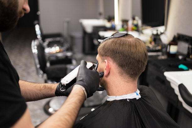 师傅在理发店为男士理发，理发师为年轻人理发图片下载