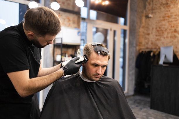 师傅在理发店为男士理发，理发师为年轻人理发图片下载