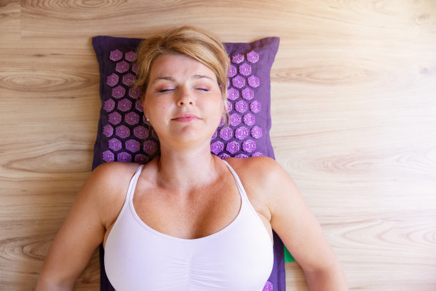 女人躺在按摩垫上缓解疼痛和压力图片下载