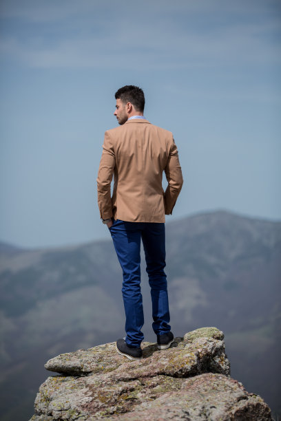 优雅的年轻人站在山顶上图片下载