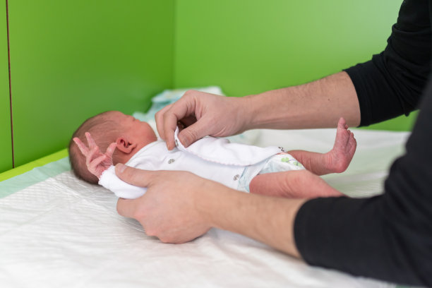在妇产医院给新生儿换尿布的父亲的手。父权观念，婴儿护理，人生新阶段图片下载