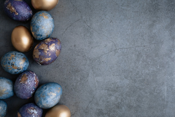 复活节卡片上有副本的文字。紫色，蓝色和金色的鸡蛋在黑暗的背景上。2022年紫色的趋势是非常接近的。天然染料karkade茶。前视图。图片下载