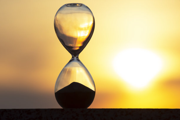 落日背景下的沙漏。时间在人生中的价值。一个永恒。图片下载