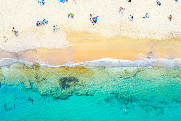 俯视图空中无人机照片美丽的海滩与美丽的绿松石水，海浪和人。假期旅游的背景。希腊图片下载