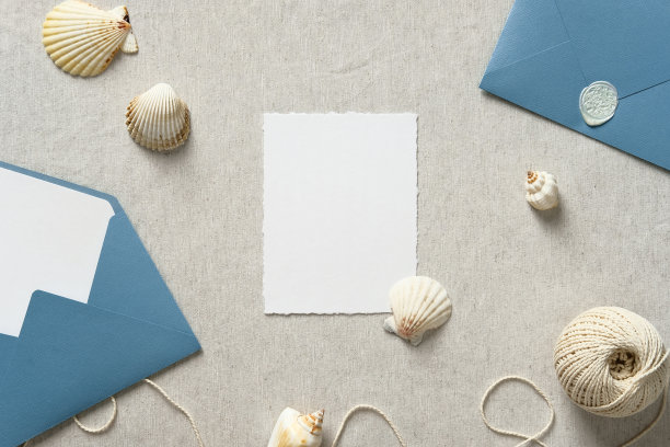 婚礼卡片模型与蓝色信封和米色背景上的海洋装饰。图片下载