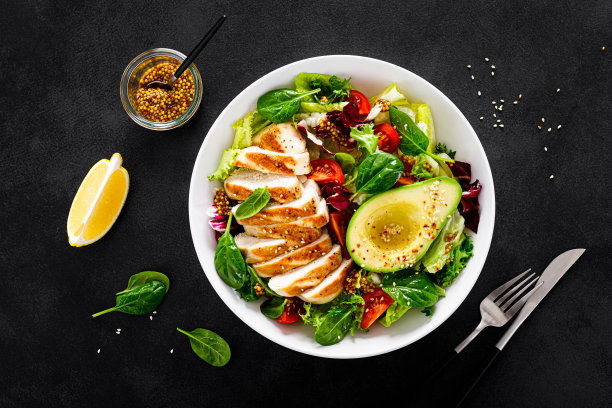 烤鸡胸肉和新鲜蔬菜沙拉番茄，鳄梨，生菜和菠菜。俯视图，平躺图片下载