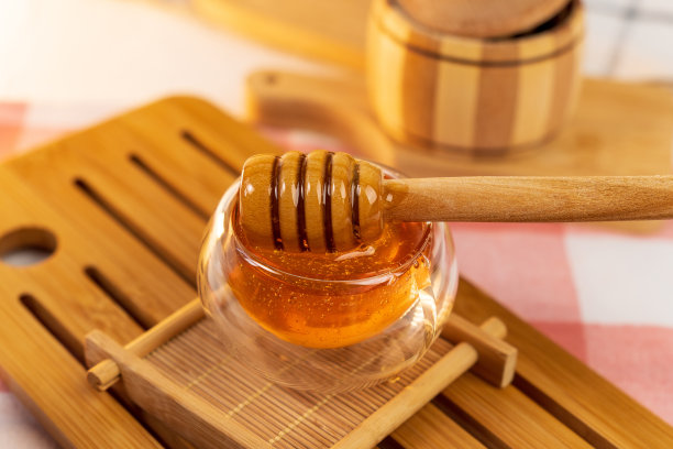 木勺与蜂蜜近距离接触，养蜂产品的理念基于有机天然成分图片下载