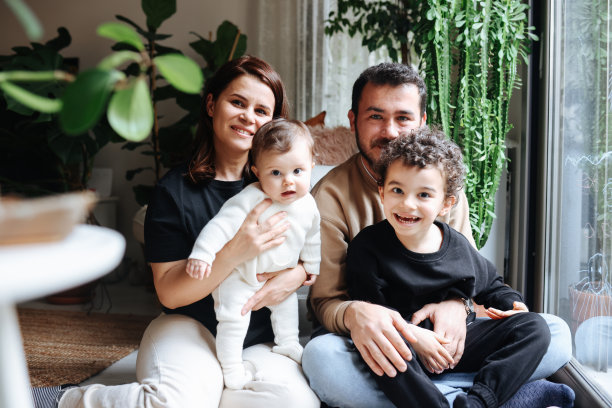 年轻的家庭与小女孩和男孩在家里的肖像图片下载