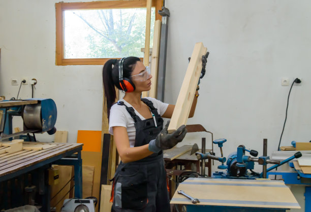 一个女木匠正在准备一块木板。图片下载