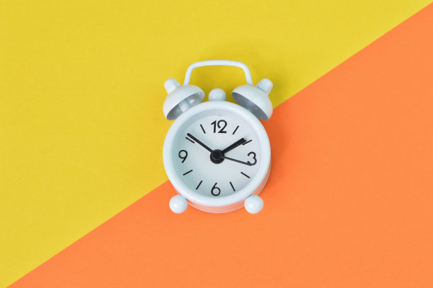 俯视图的时钟隔离在黄色和橙色的背景图片下载