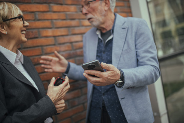 一位面带微笑的高级女士正在和她的商业伙伴交谈。图片下载