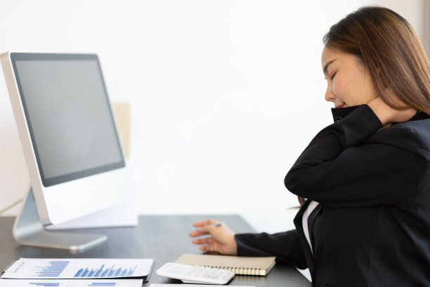 女商人的颈后疼痛。颈部疼痛的女性从辛苦工作中做伸展运动来放松。图片下载