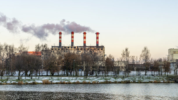 冬季带水库的电站。美丽的海边冬日夕阳和冒烟的工厂烟囱。图片下载
