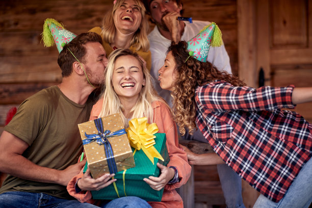 生日惊喜。朋友们拿着礼物欢呼亲吻生日女孩。感觉特别。快乐的日子，生日，庆祝。图片下载