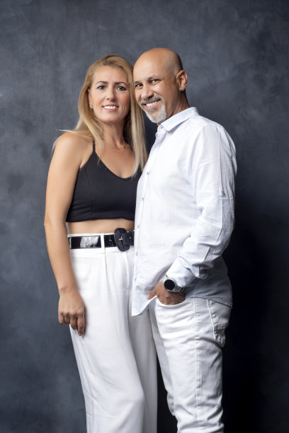 丈夫和妻子在黑暗的背景下微笑着拍照。图片下载