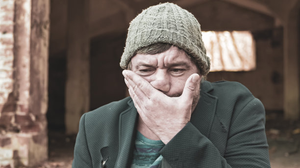 一个戴着帽子、穿着西装的可怜流浪汉用脏手擦脸，危机了现代社会的不平等概念和痛苦问题图片下载