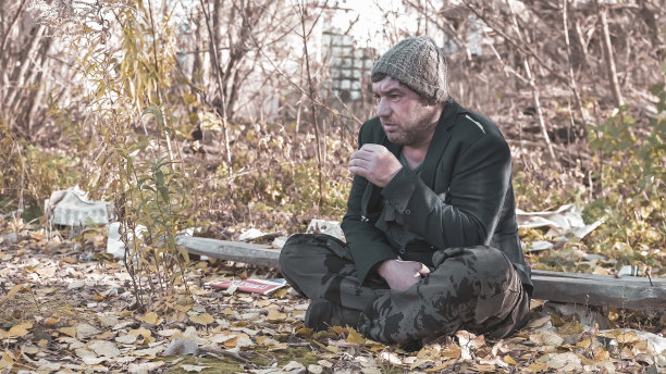 在现代社会，一个手很脏的无家可归的人在抽烟。经济衰退，失业，贫困，饥饿，养老金，全球危机，不平等问题的概念图片下载