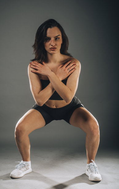 年轻苗条的体操女运动员在运动服装伸展图片下载